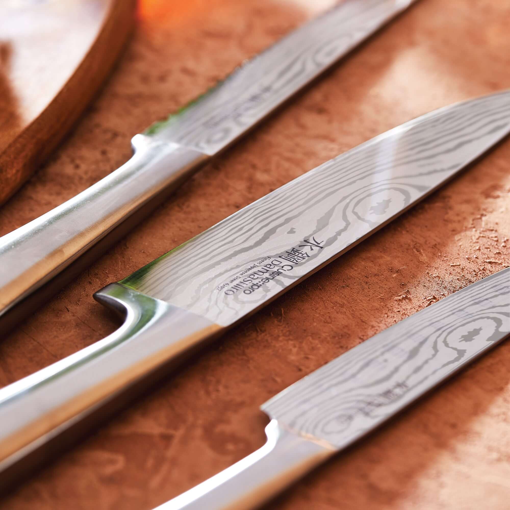 Close up of Cuisine::pro® Damashiro® Meiyo superior quality Japanese knives with 420J2 steel blades, showing detailed craftsmanship.