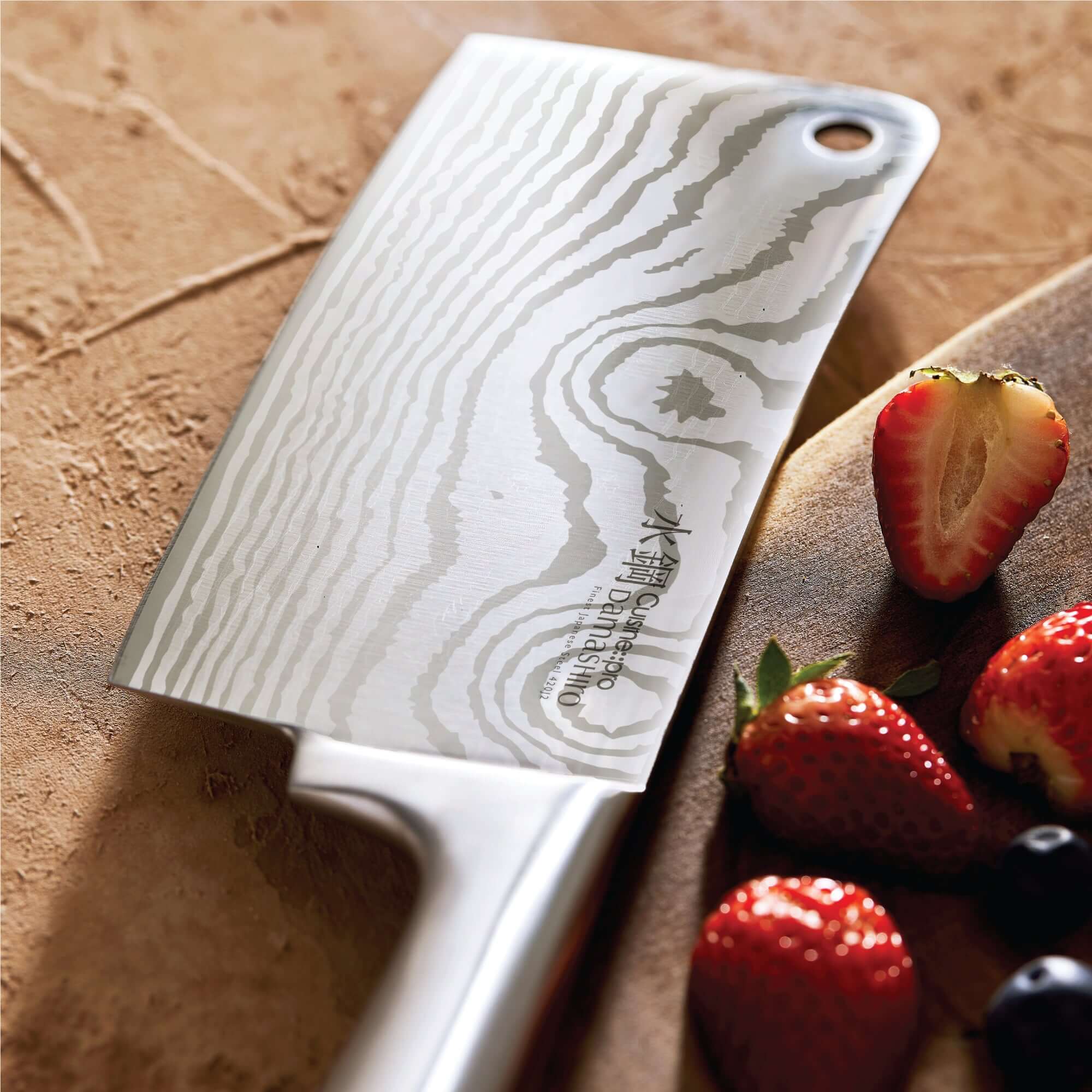 Cuisine::pro® Damashiro® Meiyo Japanese knife next to fresh strawberries and berries on a wooden cutting board.