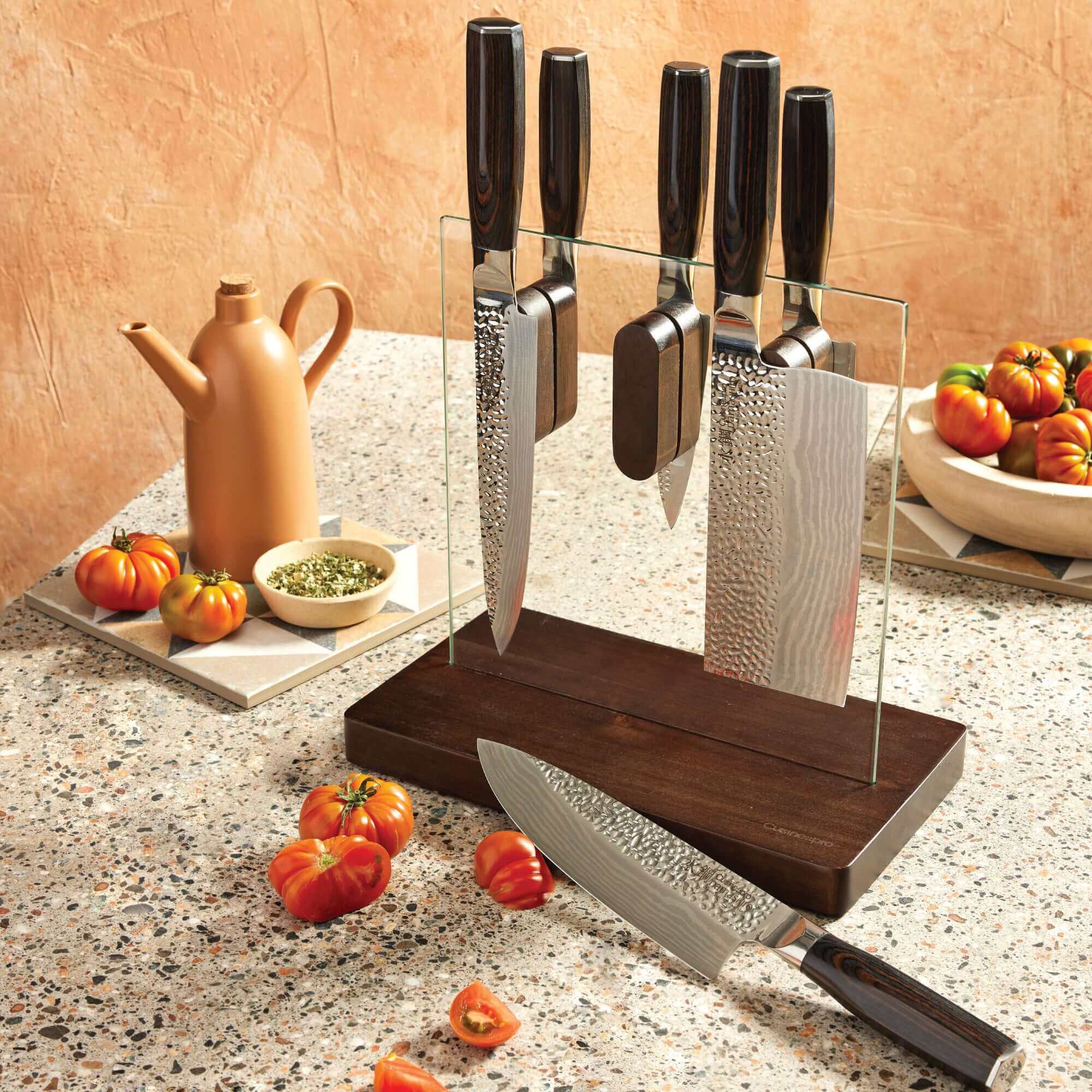 Cuisine::pro® Damashiro® EMPEROR Hikari 7 Piece Knife Block with Ash wood handles and tempered glass block on kitchen countertop with tomatoes