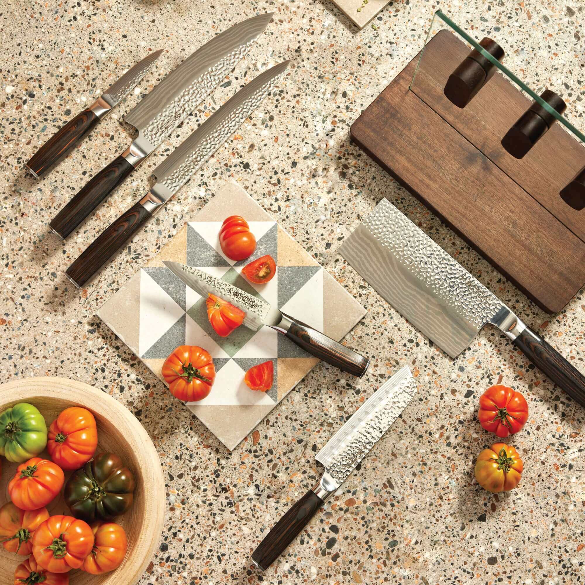 Cuisine::pro® Damashiro® EMPEROR Hikari 7 Piece Knife Block with Ash wood handles on kitchen counter with tomatoes.