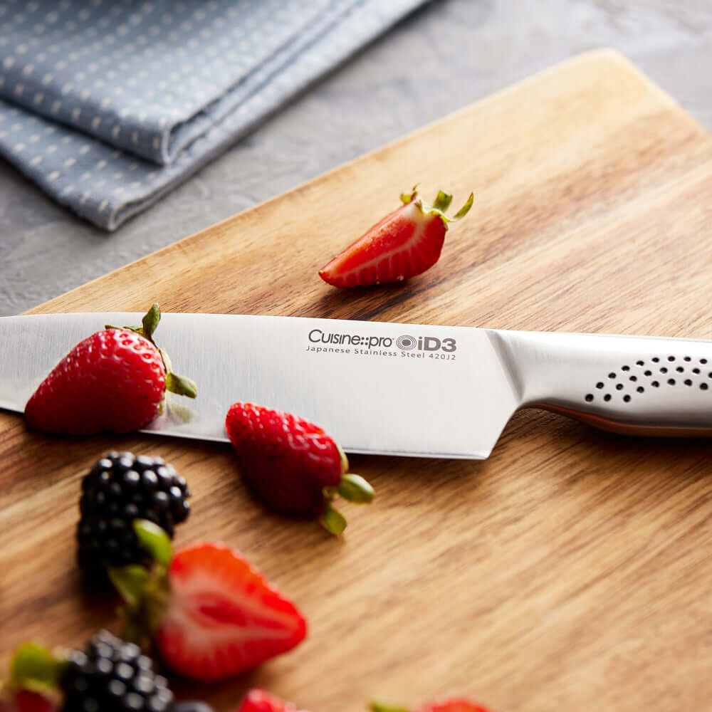 Cuisine::pro® iD3® Chefs Knife with 6-inch Japanese Steel Blade on Wooden Cutting Board with Strawberries and Berries