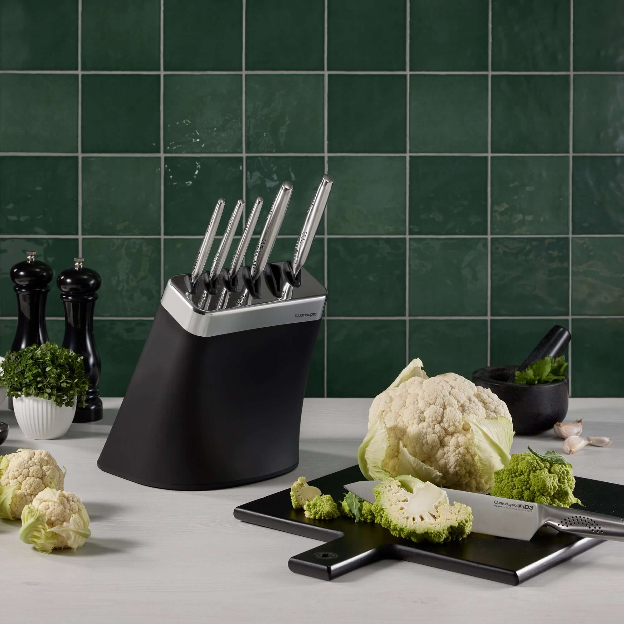 Cuisine::pro® iD3® Kobe 7 Piece Knife Block with Japanese steel knives on a kitchen counter with chopped cauliflower.