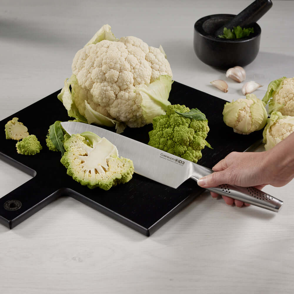 Cuisine::pro® iD3® Kobe Knife slicing cauliflower on a black cutting board